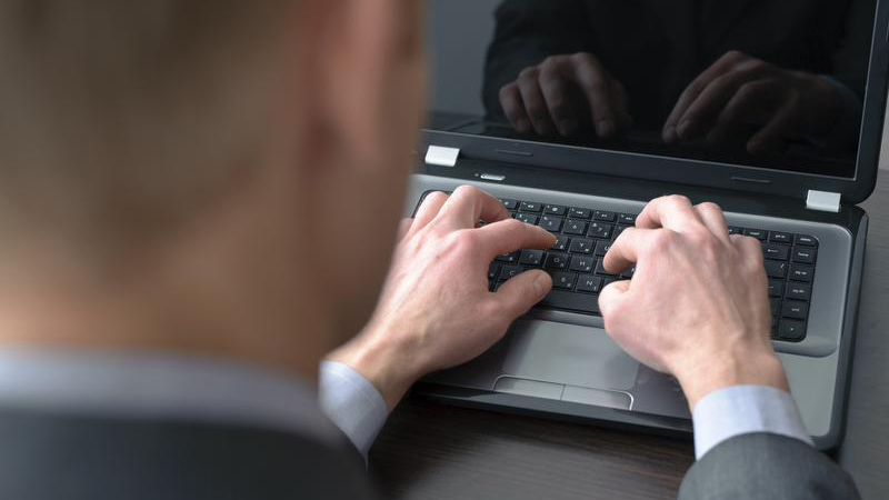Man’s hands on laptop keyboard.
