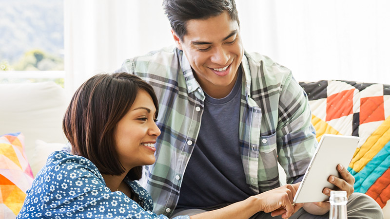 A woman and a man looking at a tablet together. A woman and a man looking at a tablet together.