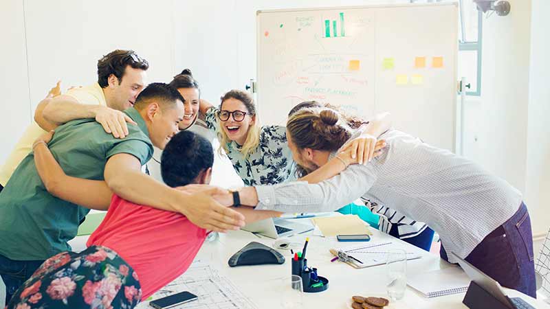 Equipo de trabajo abrazados