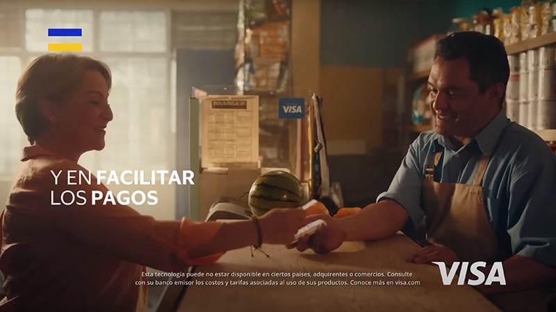 Hombre que atiende un comercio aceptando pagos con Visa